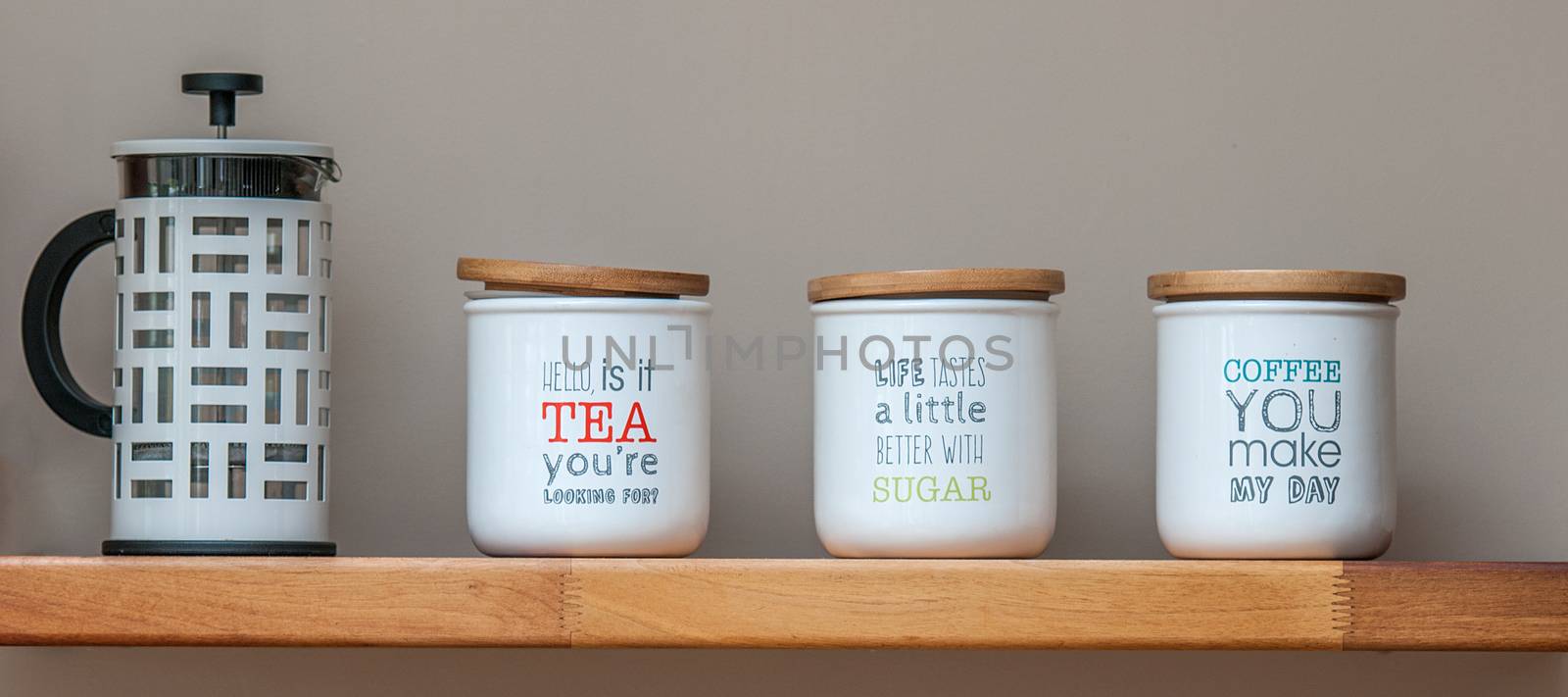 tea and coffee storage jars and a coffee plunger on a wooden shelf by sirspread