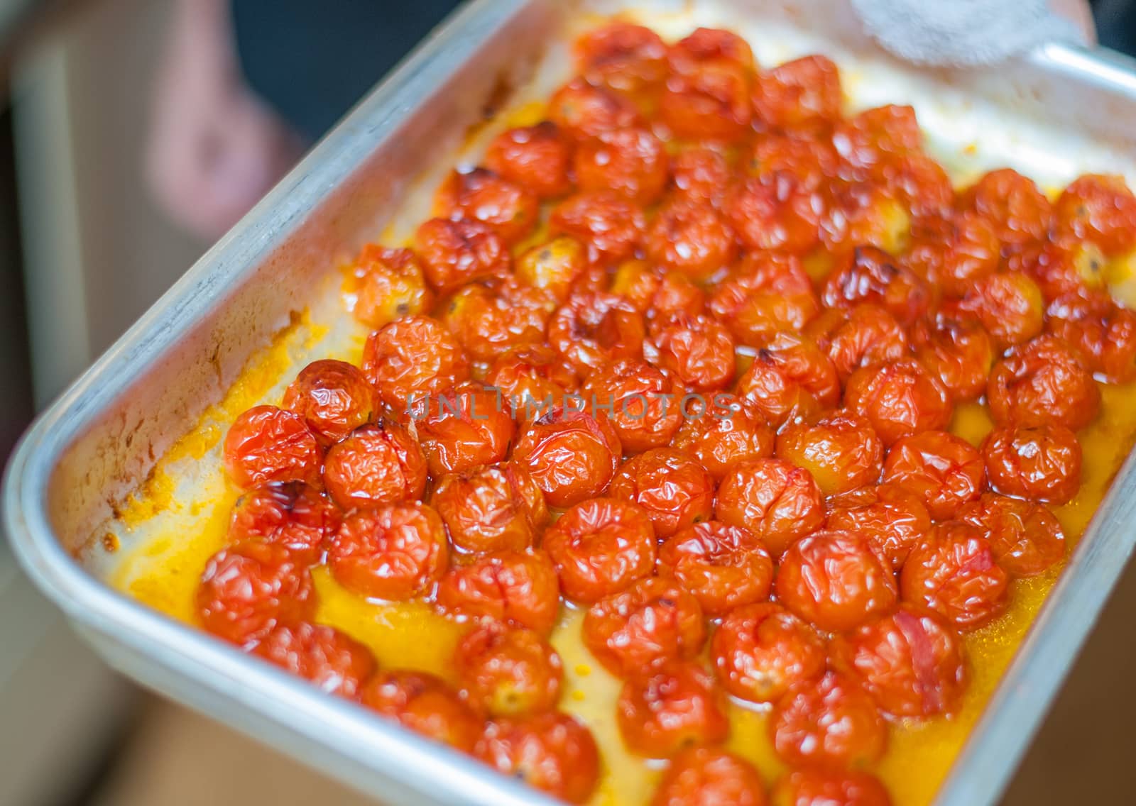 cooked red cherry tomatoes on a baking tray straight from the oven by sirspread