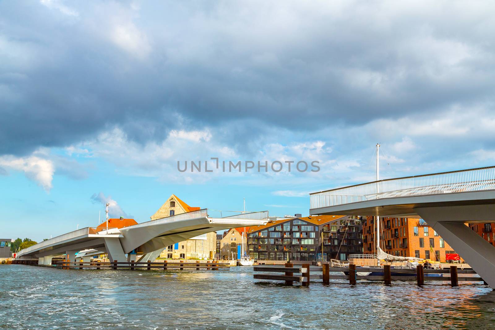 Drawbridge in Copenhagen, Denmark. Cityscape of Copenhagen, view on the drawbridge leading to popular street of Nyhavn in Copenhagen. A modern drawbridge in central Copenhagen near Nyhavn pier.