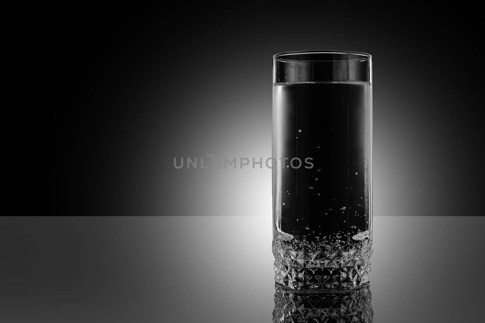 Glass of water on a black background. by 9parusnikov