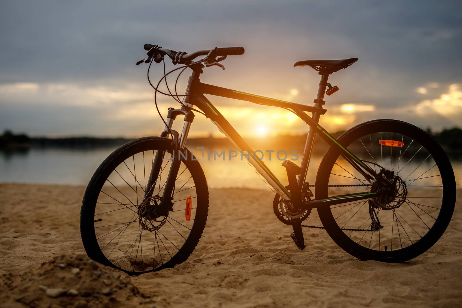 Silhouette of sports bicycle on a beach. Sunset