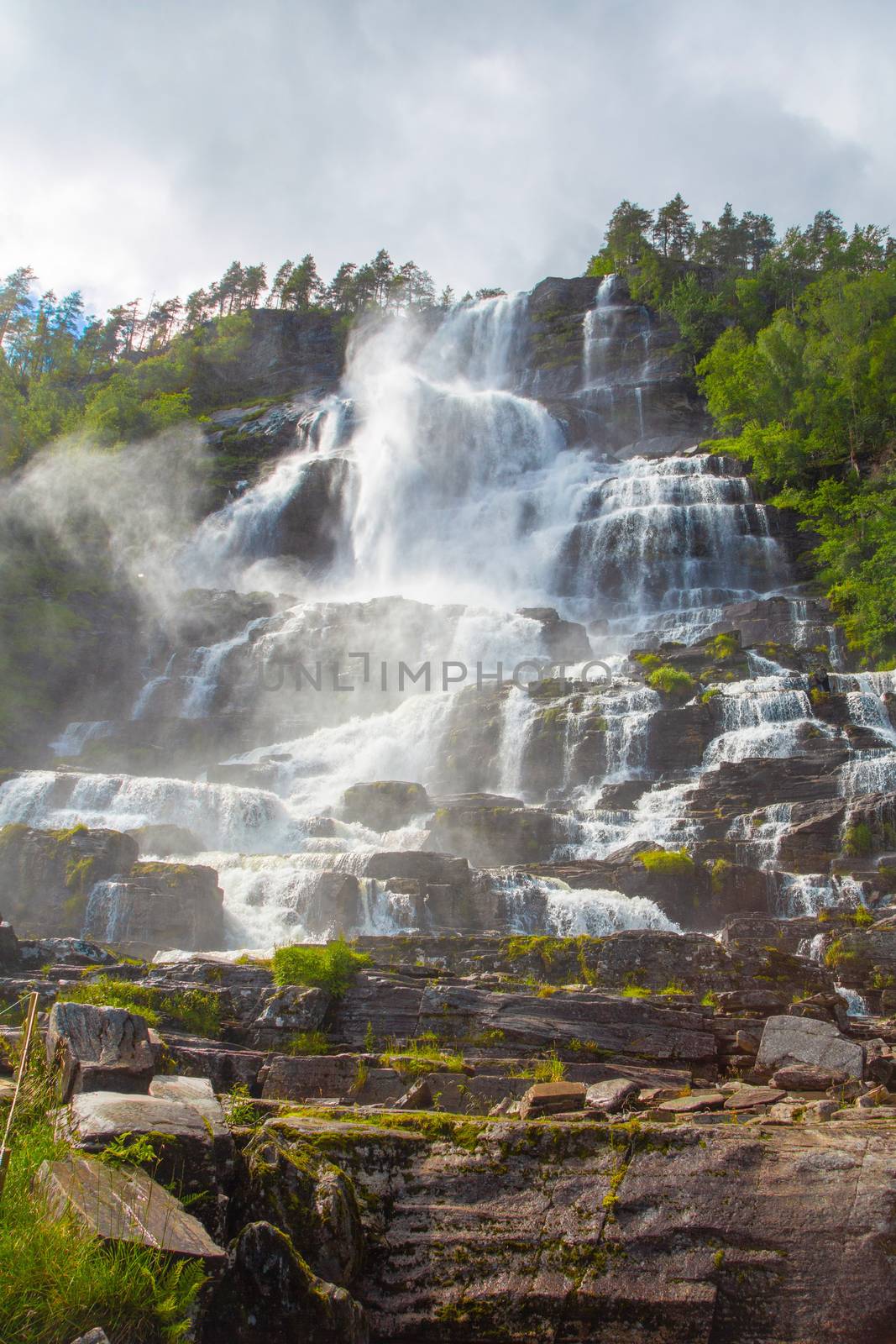 Falls in mountains of Norway in rainy weather. White waterfall. Tvindefossen Waterfall near Voss, Norway. Norway nature and travel background.