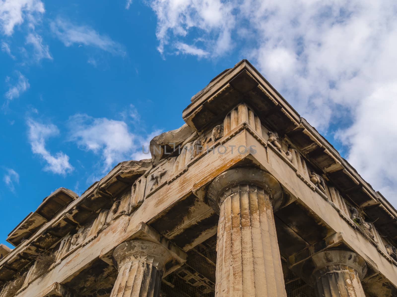 Ruins of the Greek building. Close up of ancient Greco-Roman columns. Close up low angle architectural view of ancient Greek ruins. Sunny day with clear blue sky in olympia, Greece.