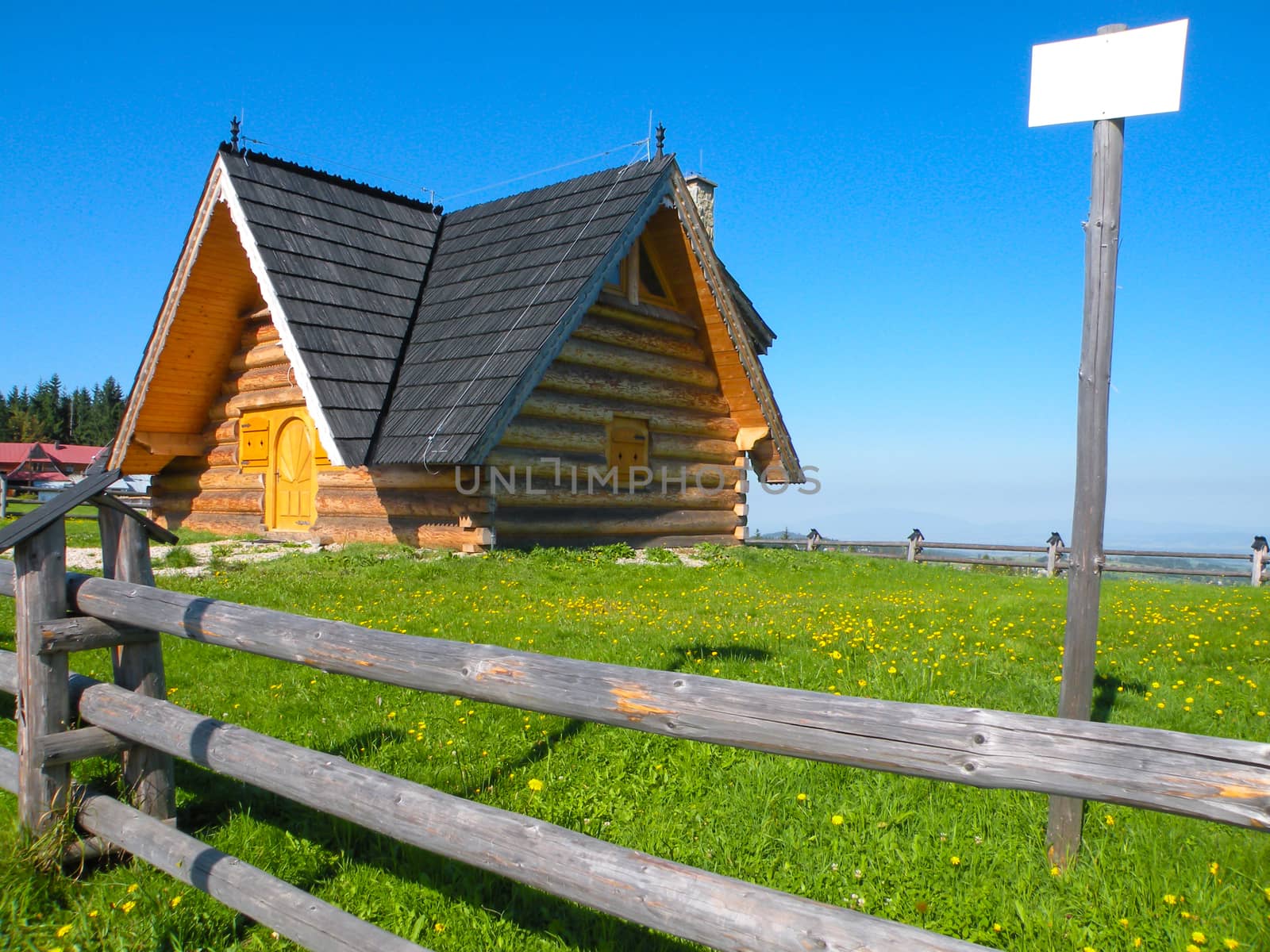 Traditional wooden house in small village in the mountains under sky with sign plate for your inscriptions