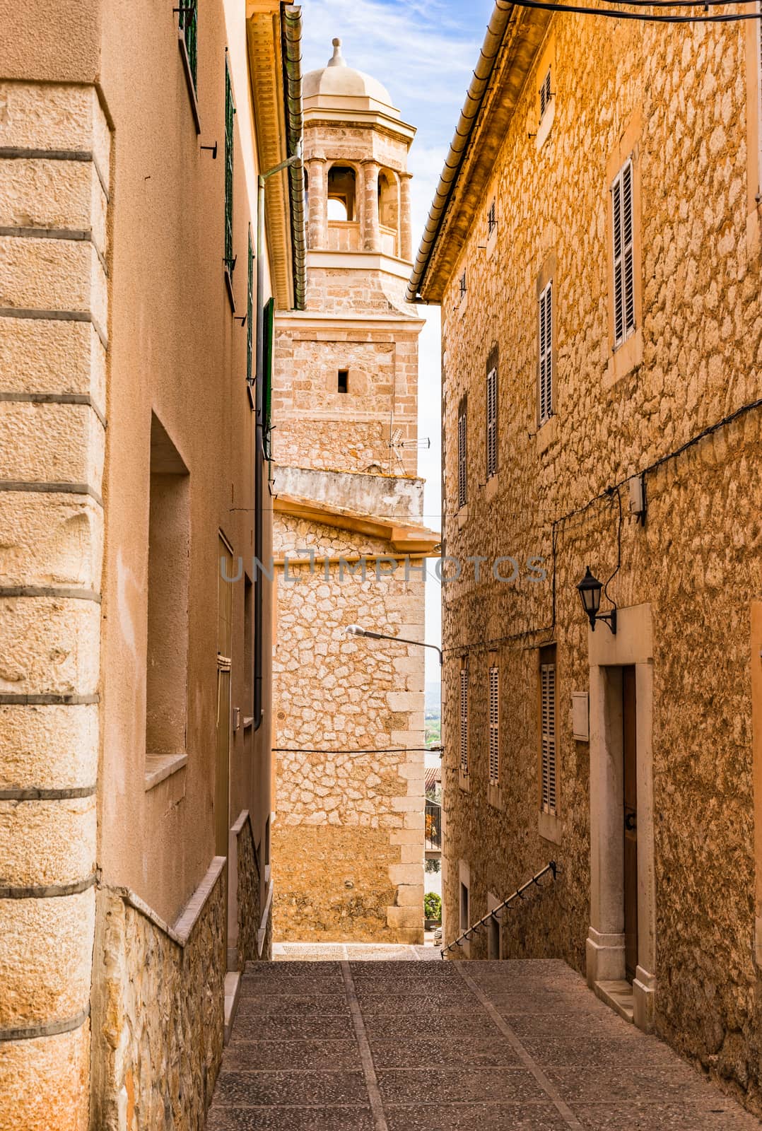 Beautiful view of street whith church steeple in old village of Lloseta on Mallorca island, Spain