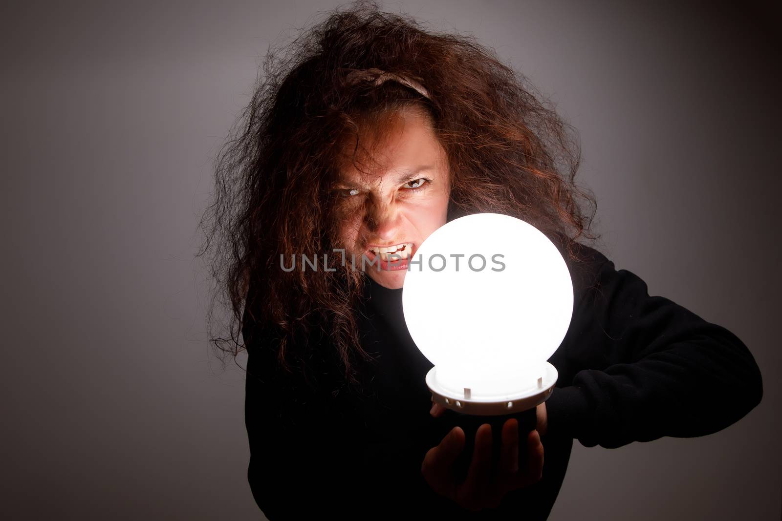 Fortuneteller holding a glowing ball in her hands.