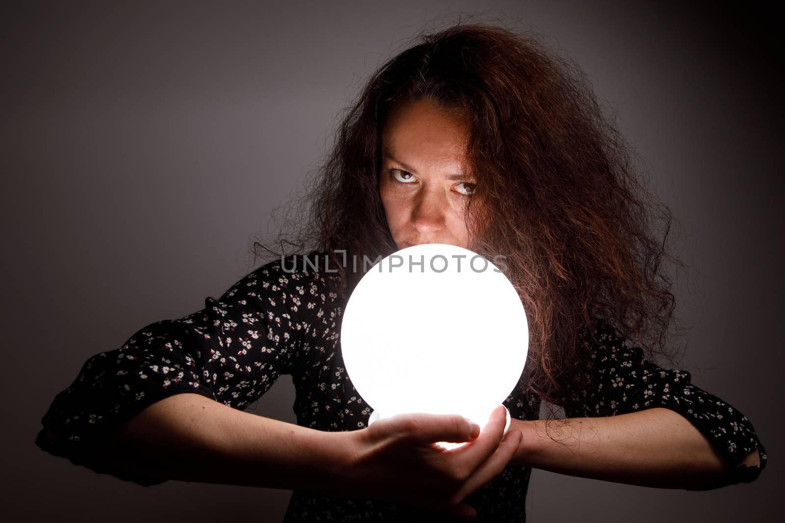 Woman with a luminous ball. Demonic look