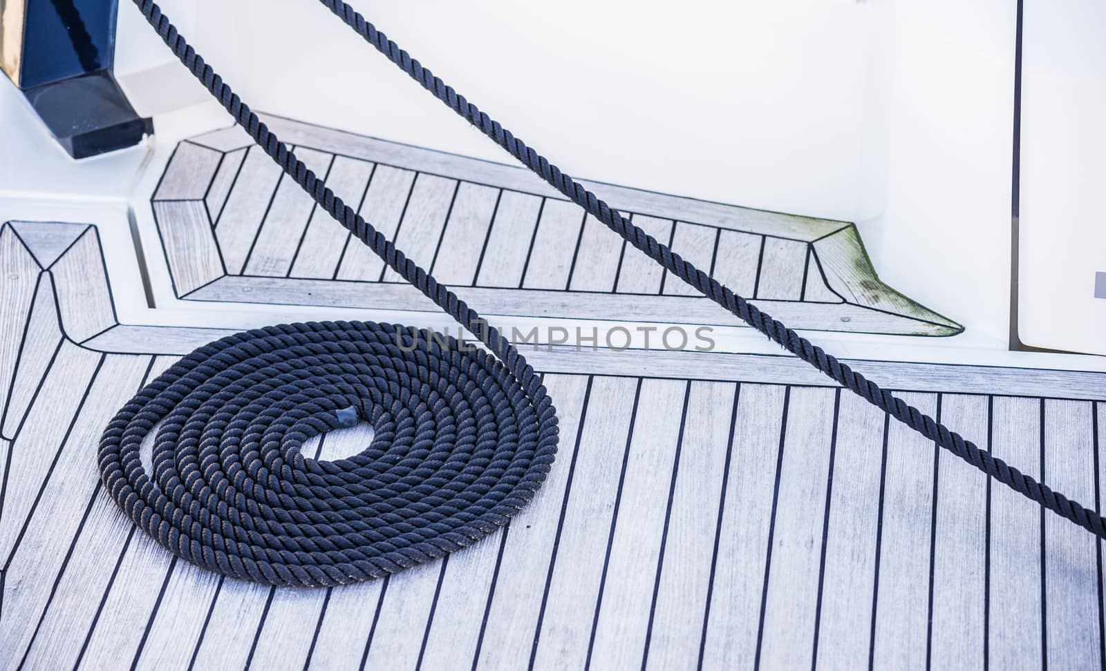 View of swirled curled nautical rope bow on boat deck, mooring line