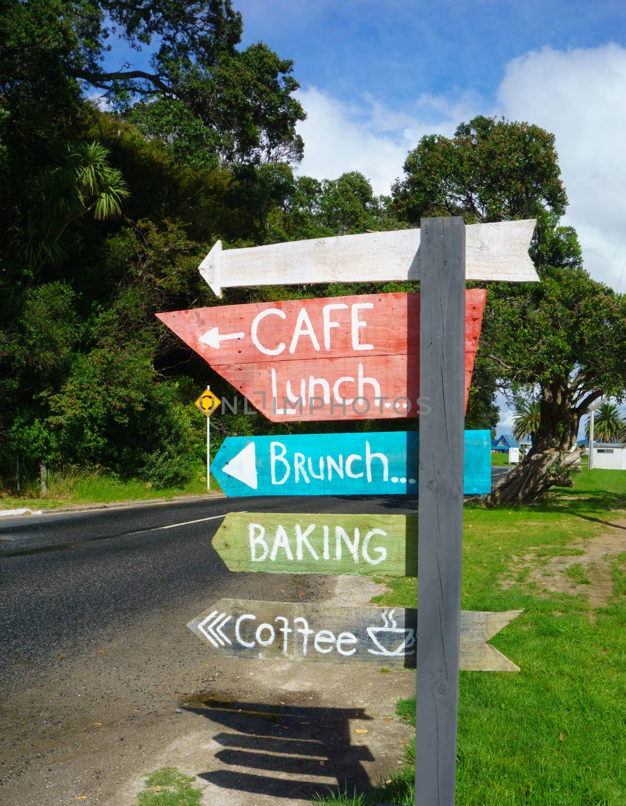Rustic sign point way to cafe advertising lunch, brunch and coffee.  on side of street.