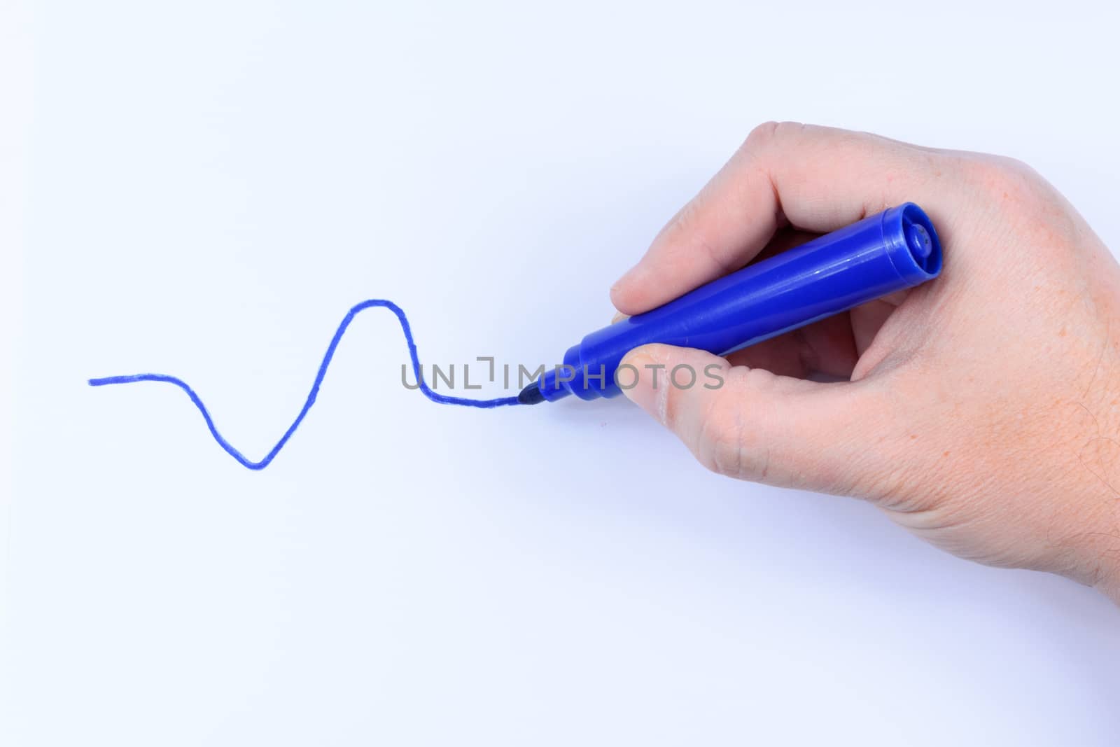 Hand holding a blue  pen drawing a wavey line isolated on white background