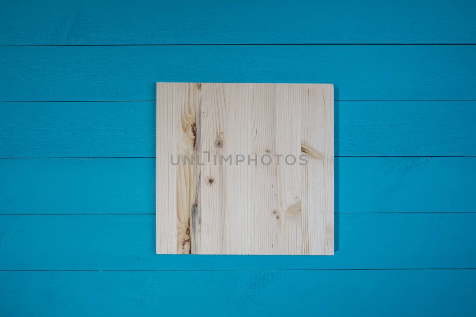 a natural wooden tablet on a blue wooden table
