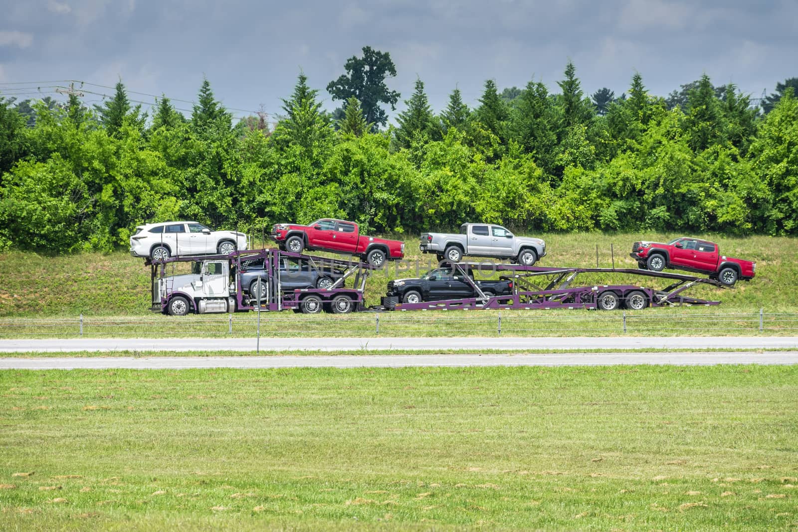 Automobile hauling truck photographed at a distance on a hot summer day. Heat waves from the pavement creates slight shimmering effect.
