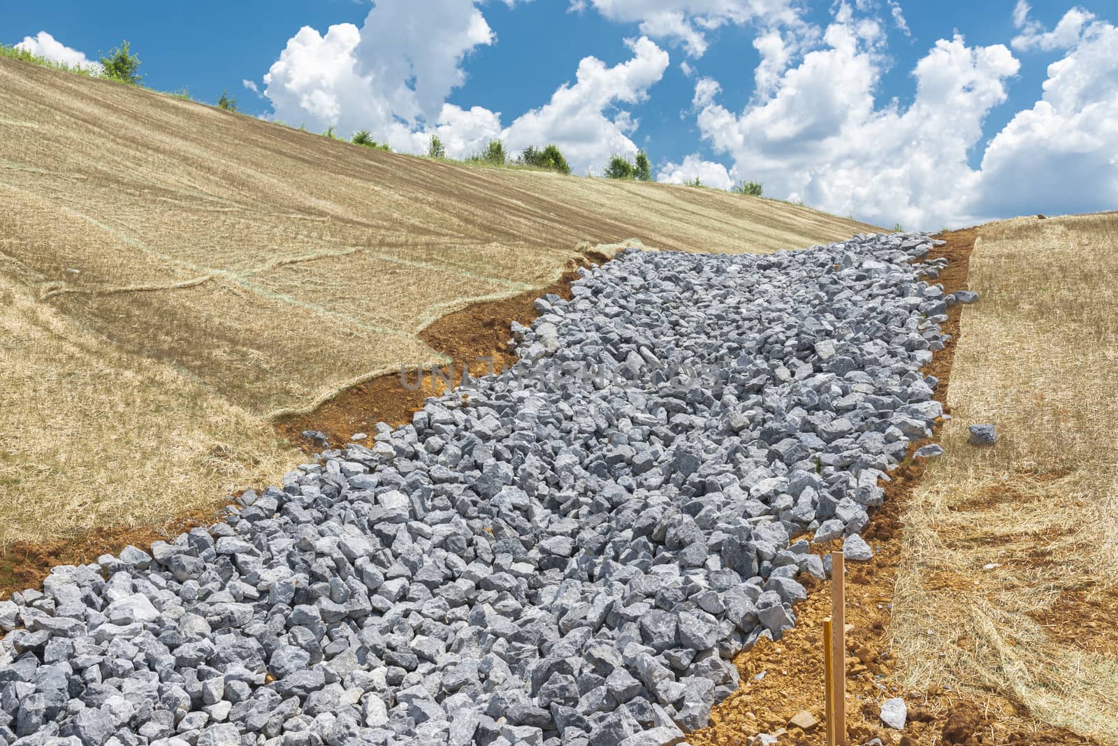 Horizontal shot of a crushed rock base for a new drainage ditch.