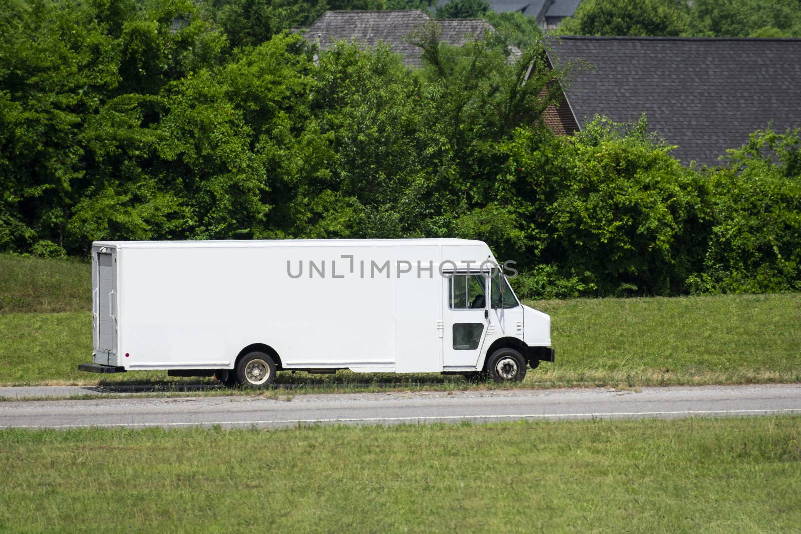 Blank White Panel Truck Exits Freeway Against Green Background by stockbuster1