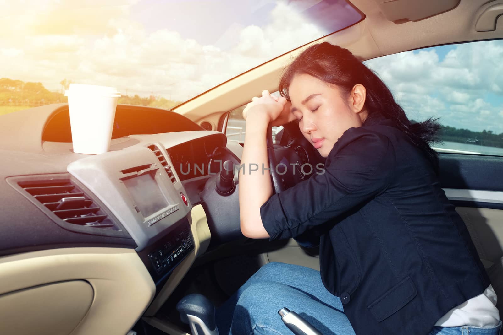 Tired young woman asleep in her car