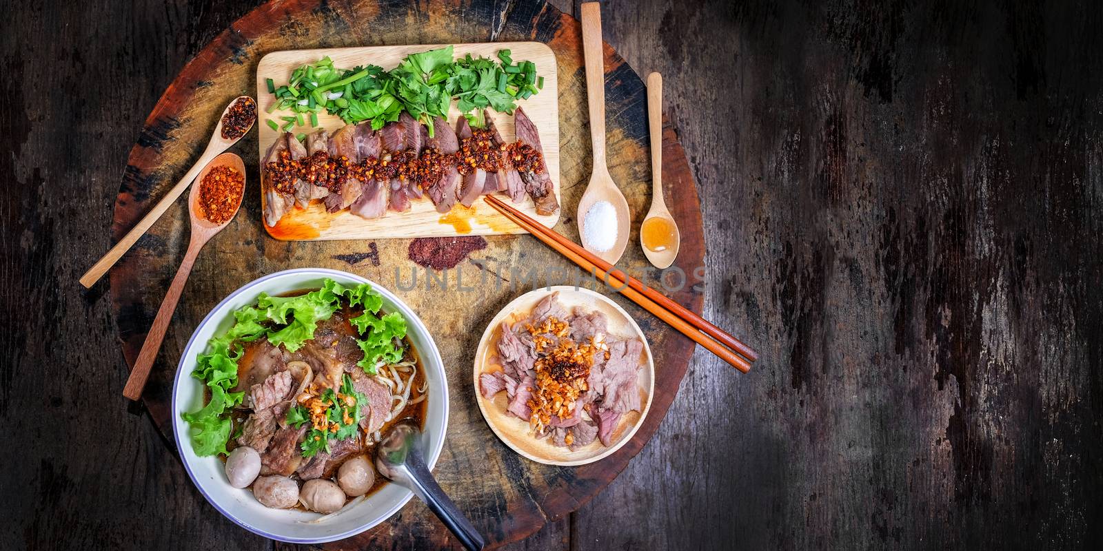 Thai food Noodle soup with beef on wood background by Surasak