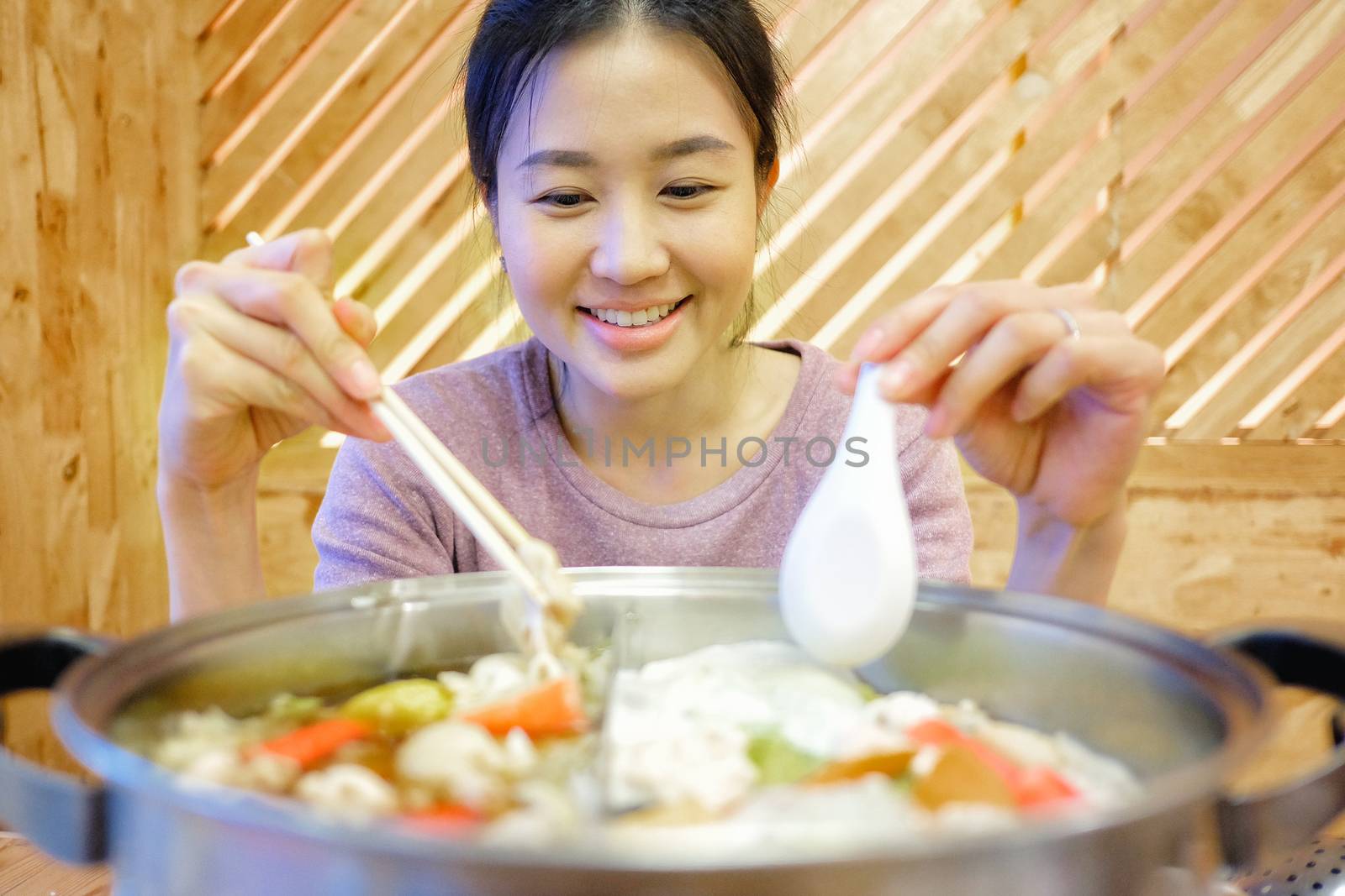 a young woman enjoy eating Shabu-Shabu japanese hot pot