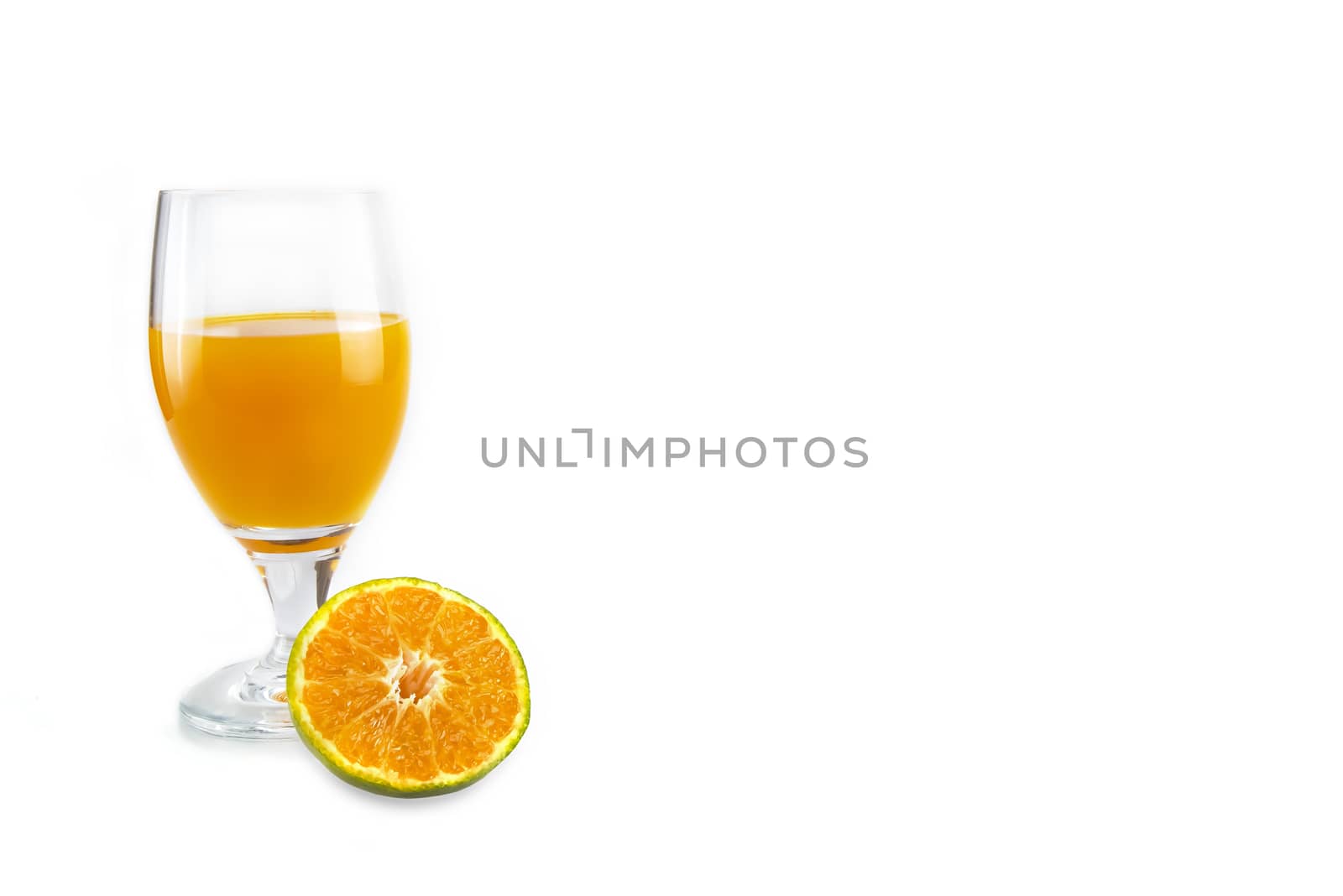 A glass of fresh orange juice with a slice of cut orange by Nawoot