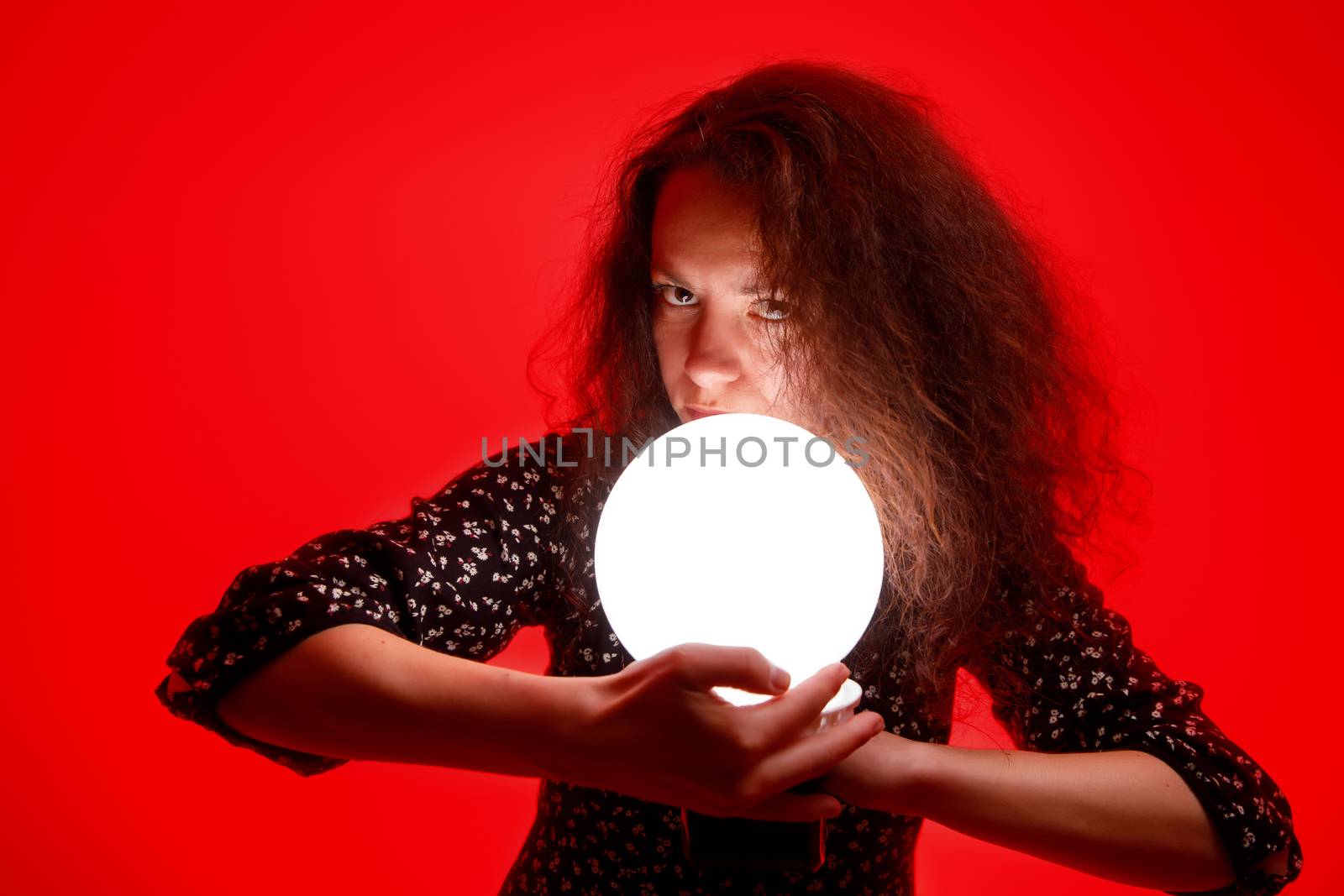 Woman with a luminous ball. Red background