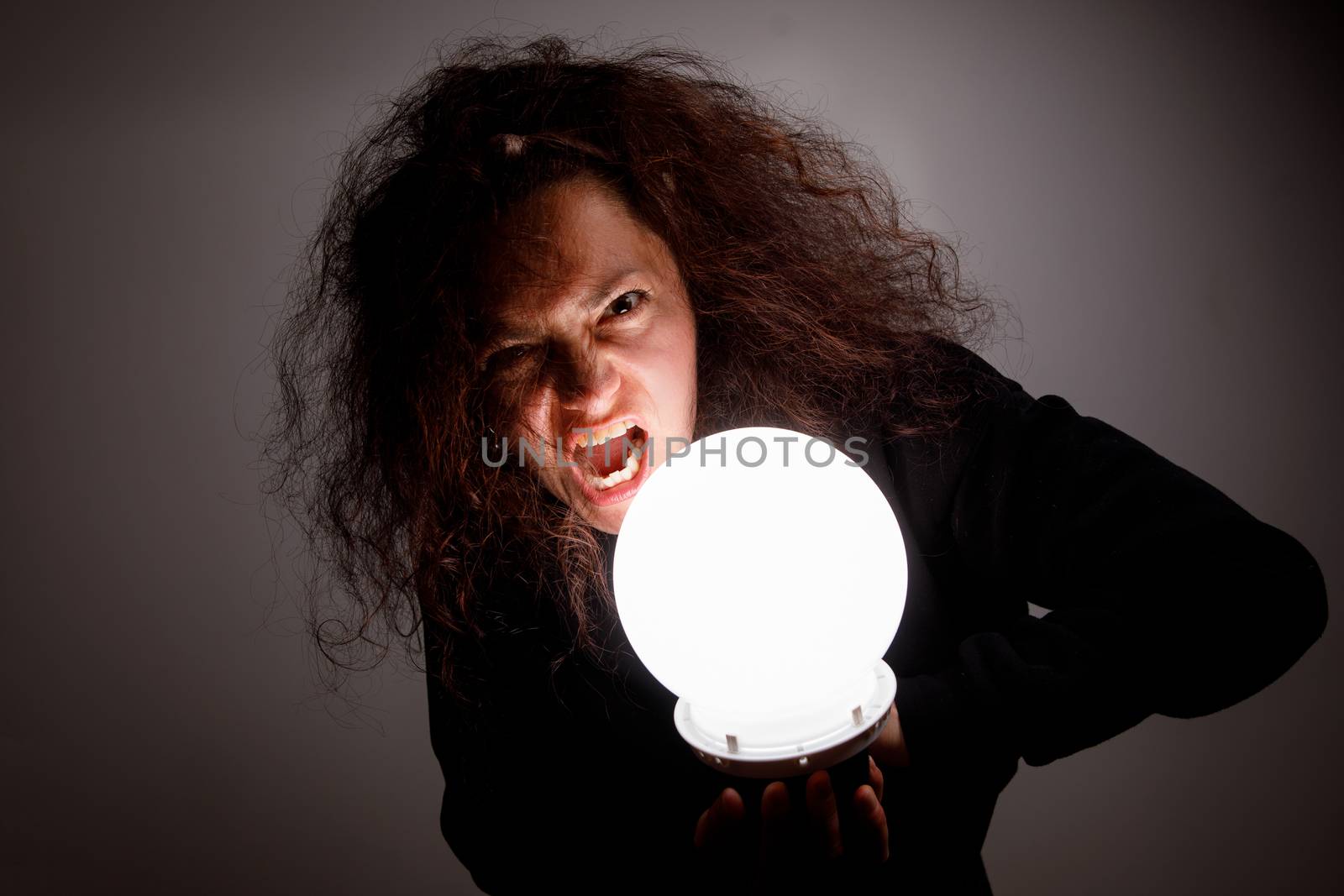 Woman with a luminous ball. Demonic look