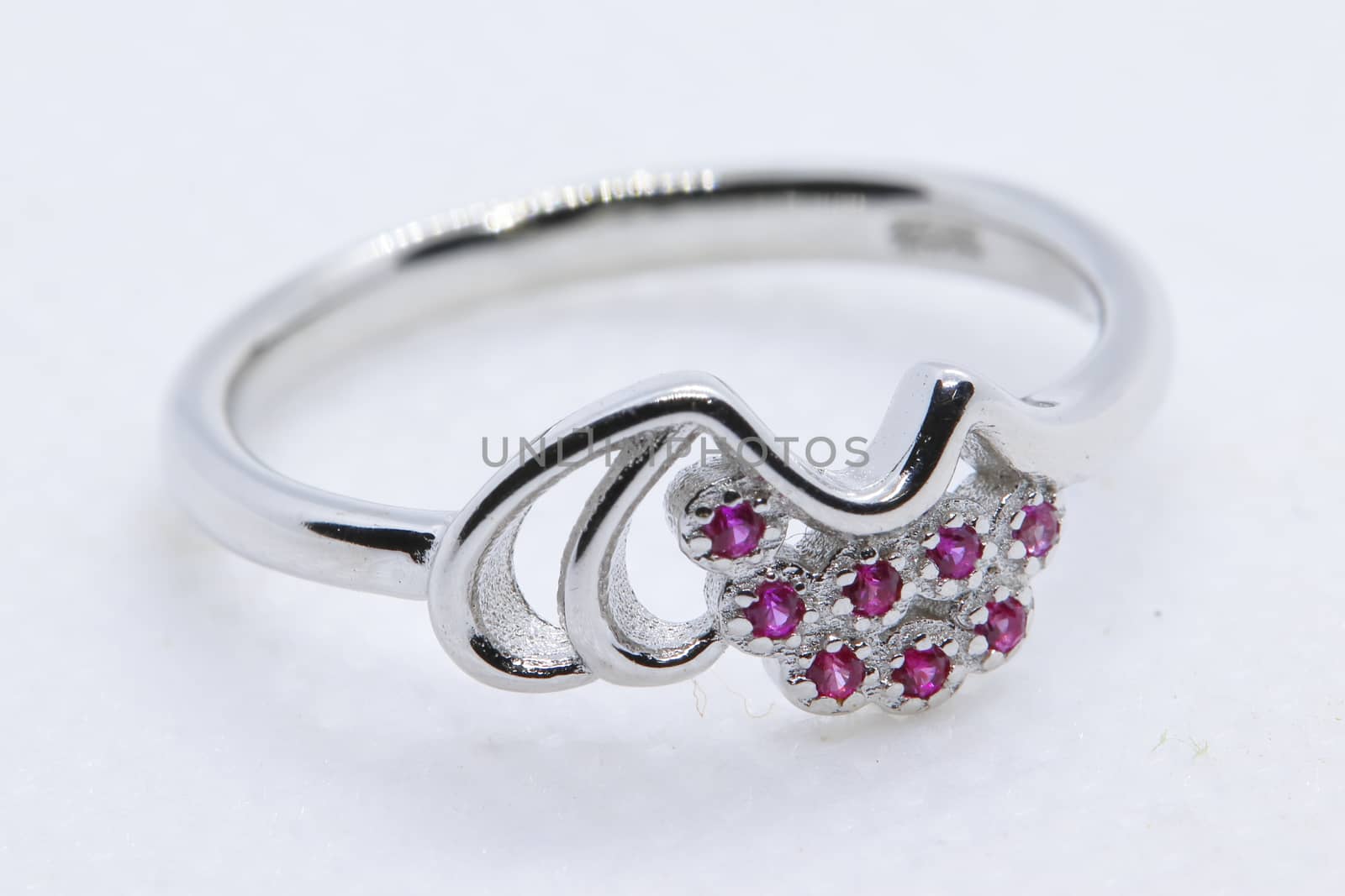 macro shot of A silver ring with pink nagina or stone for women with white background