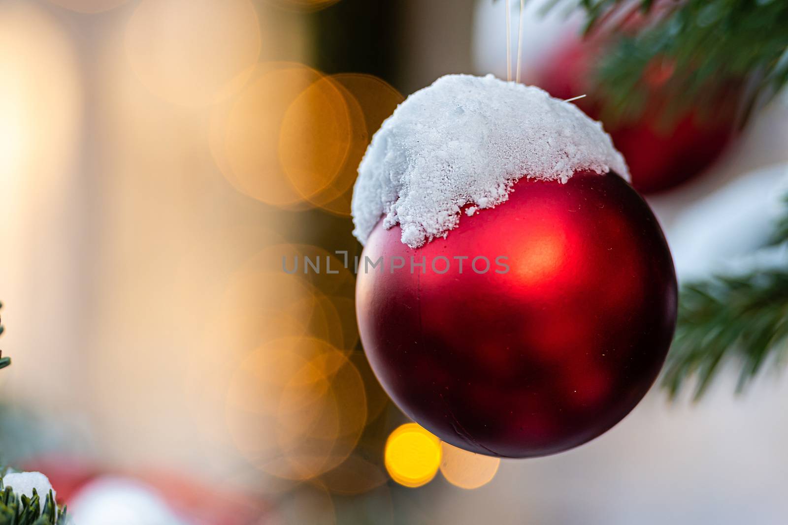 Colorful decorations on snow-covered Christmas tree branches - image