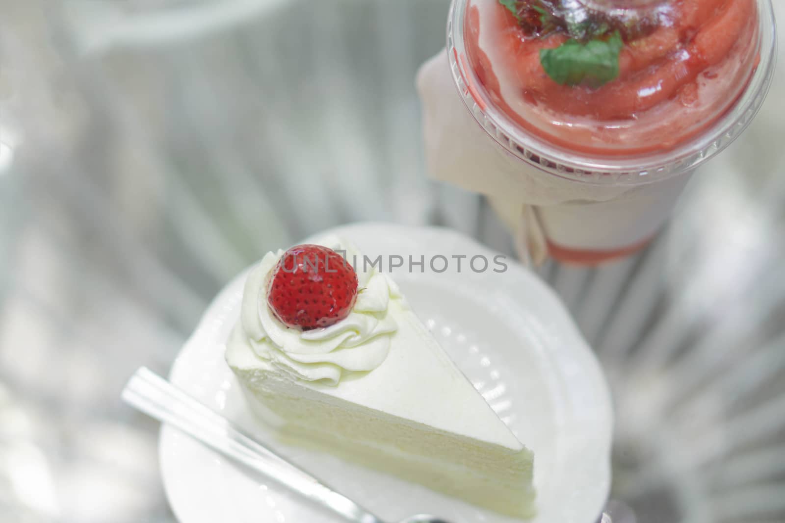 Closeup  strawberry smoothie and milk cake delicious on glass table background, selective focus