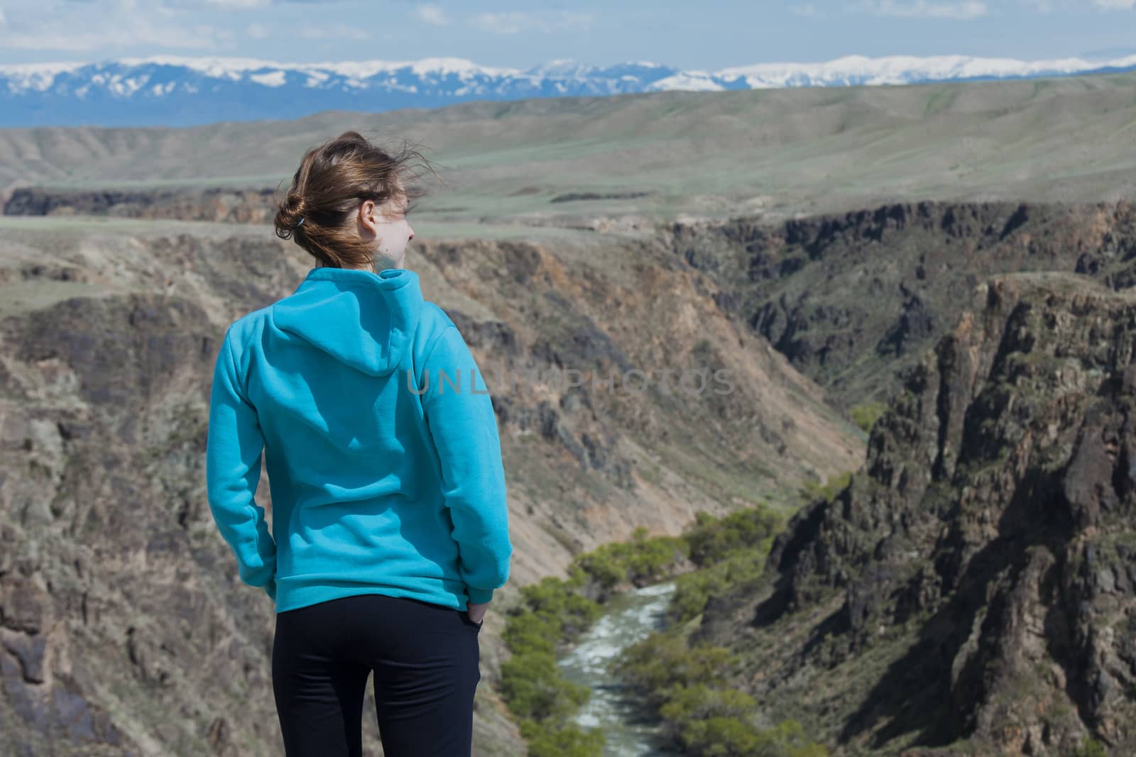 The girl costs on the brink of break and looks at mountains