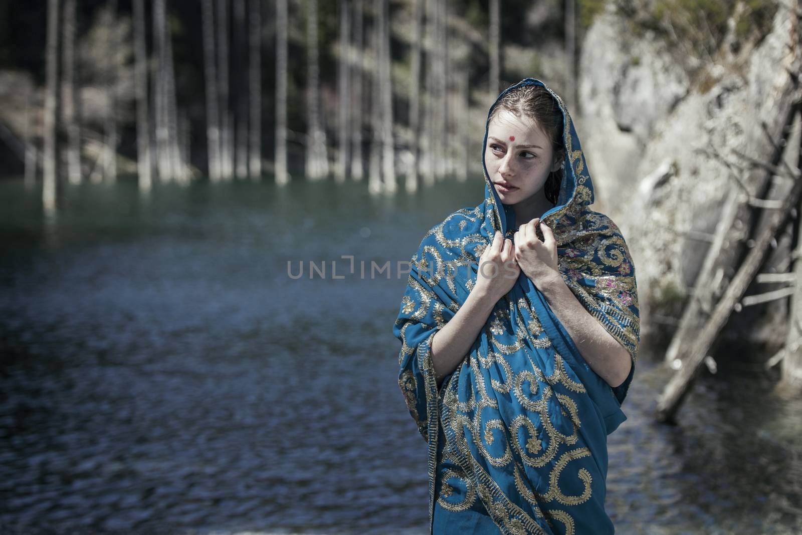 The girl of the European appearance poses in the Indian sari at Kaindy lake