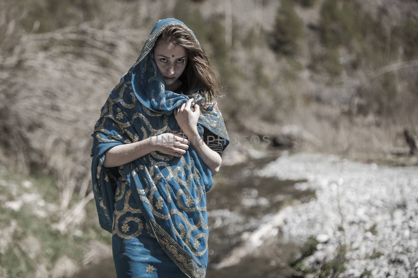 The girl of the European appearance poses in the Indian sari at Kaindy lake