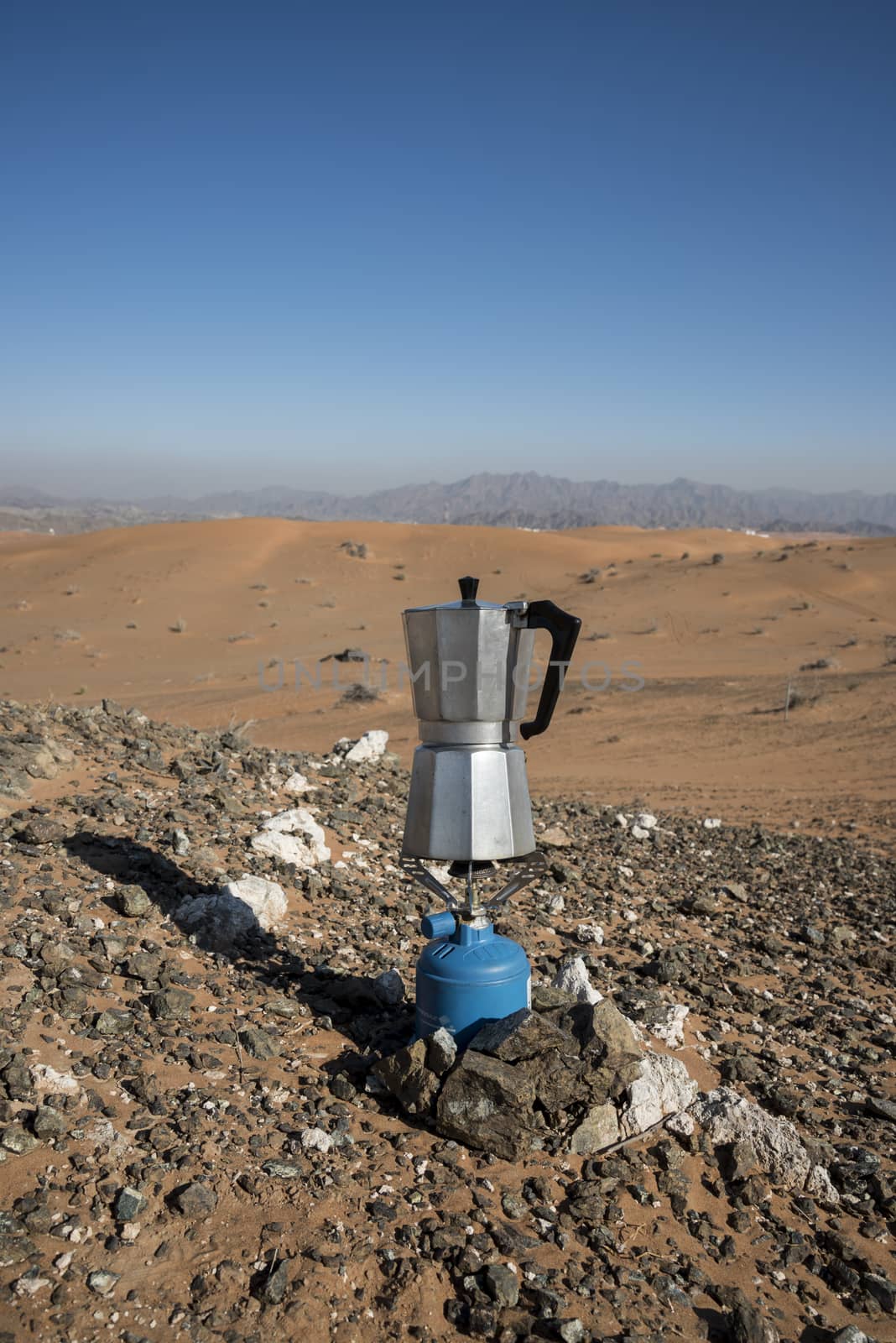 Italian Coffee maker boiling at a fireplace in the desert on camping gaz
