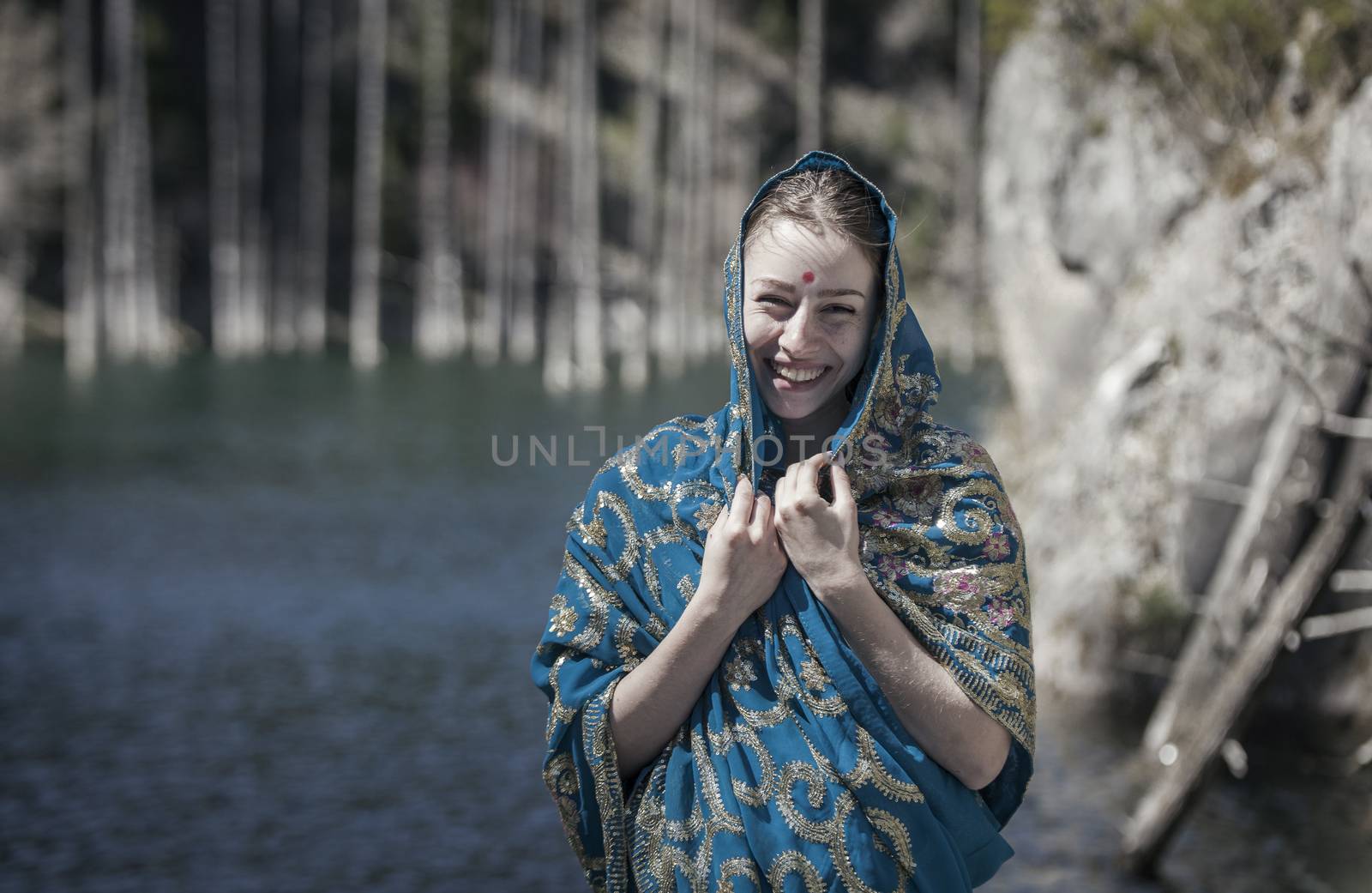 The girl of the European appearance laugh and poses in the Indian sari at Kaindy lake