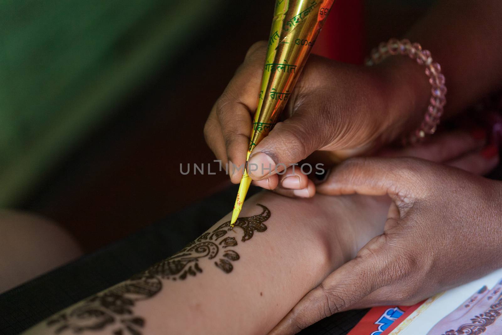 The woman the Indian does a tattoo henna to the girl