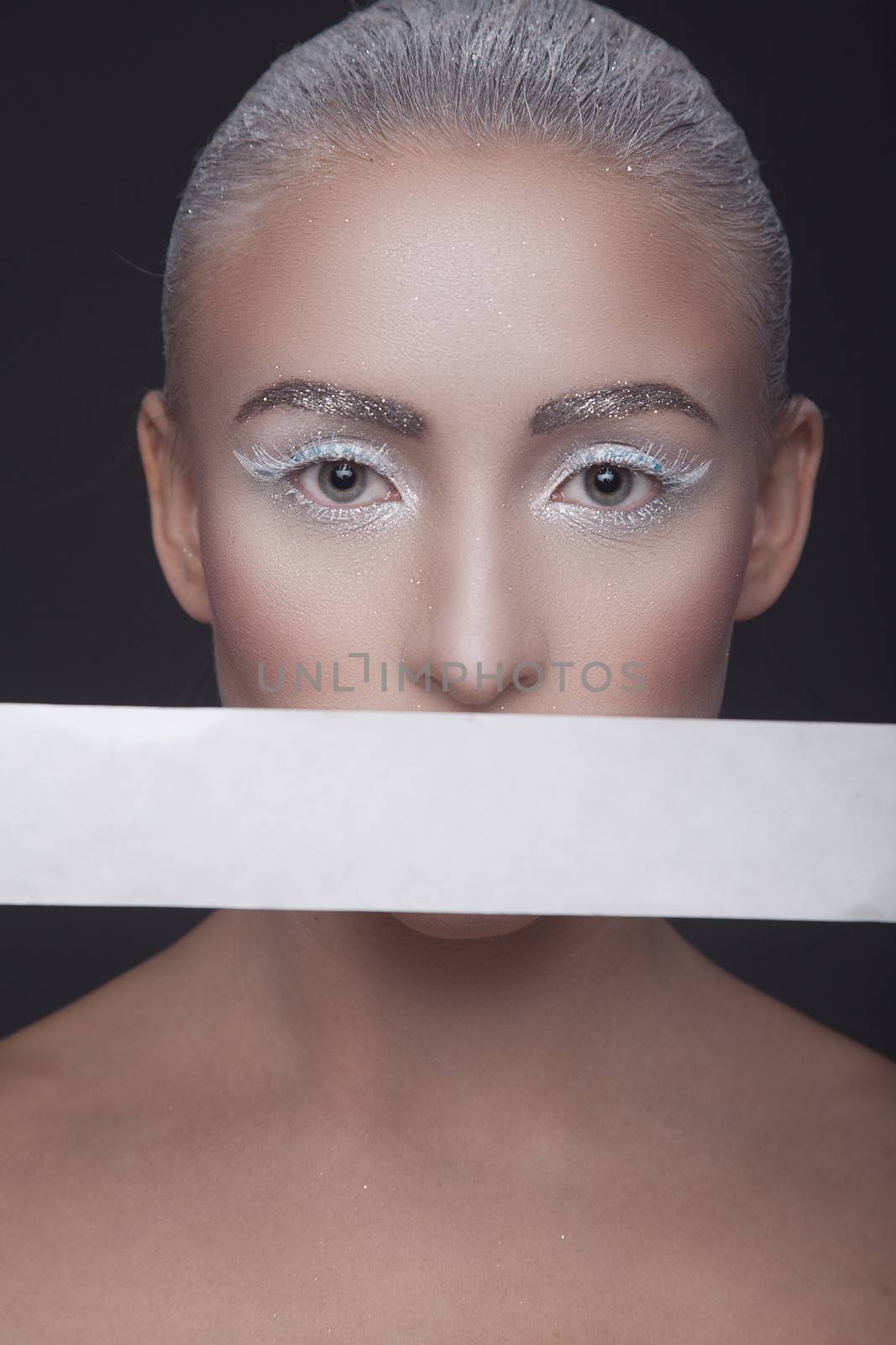Beauty studio portrait of a beautiful girl with a white stripe around the mouth