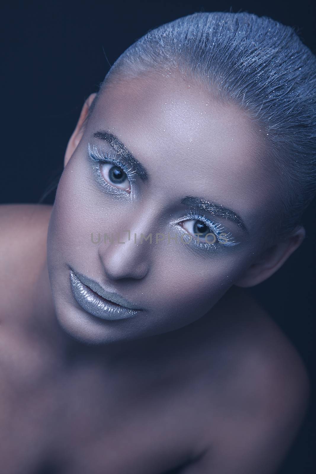 Studio beauty portrait of a beautiful girl with a makeup of snow queen