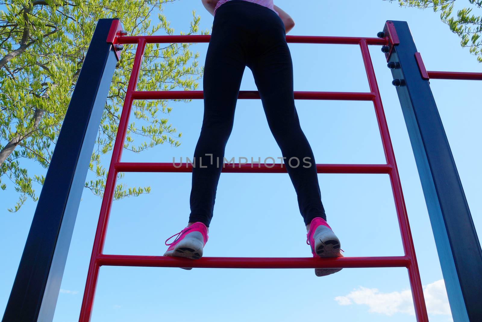 girl stands on a sports ladder, bottom view