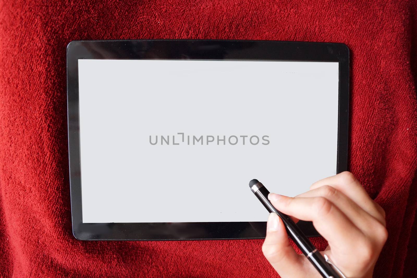 hand writes with a stylus on the white screen of the tablet, mock up. by Annado