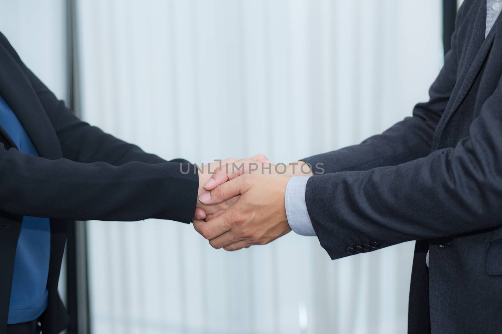 Handshake of businessman and businesswoman after successful business meeting.