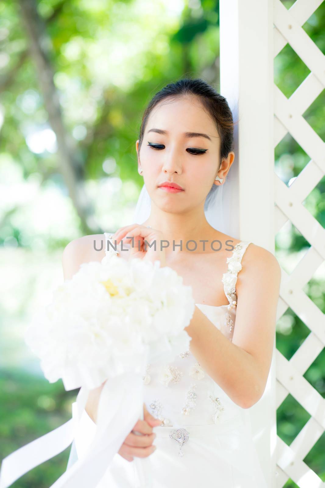 beautiful young woman on wedding day in white dress in the garden. Female portrait in the park - Selective focus.