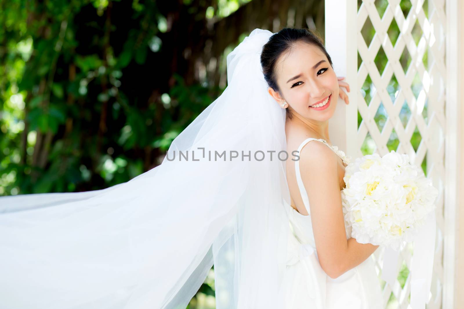 beautiful young woman on wedding day in white dress in the garden. Female portrait in the park - Selective focus.