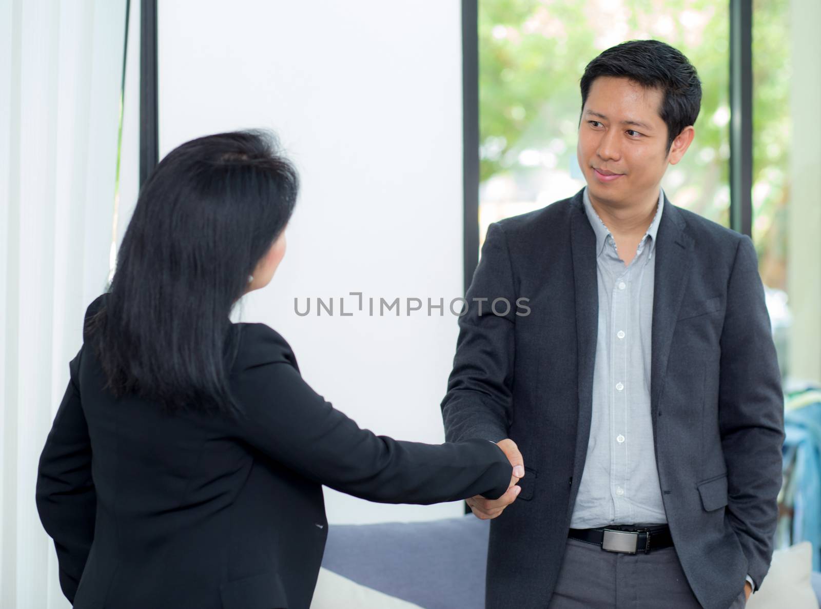 Handshake of businessman and businesswoman after successful busi by nnudoo