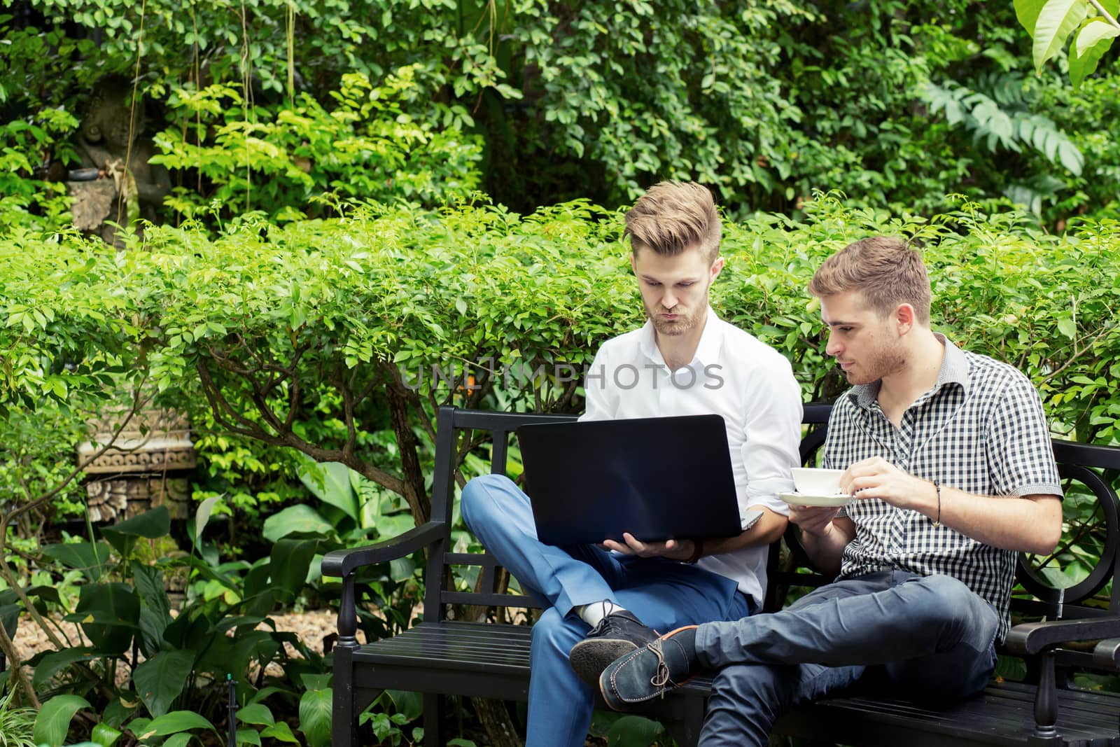 Two business people use of the notebook computer at outdoor