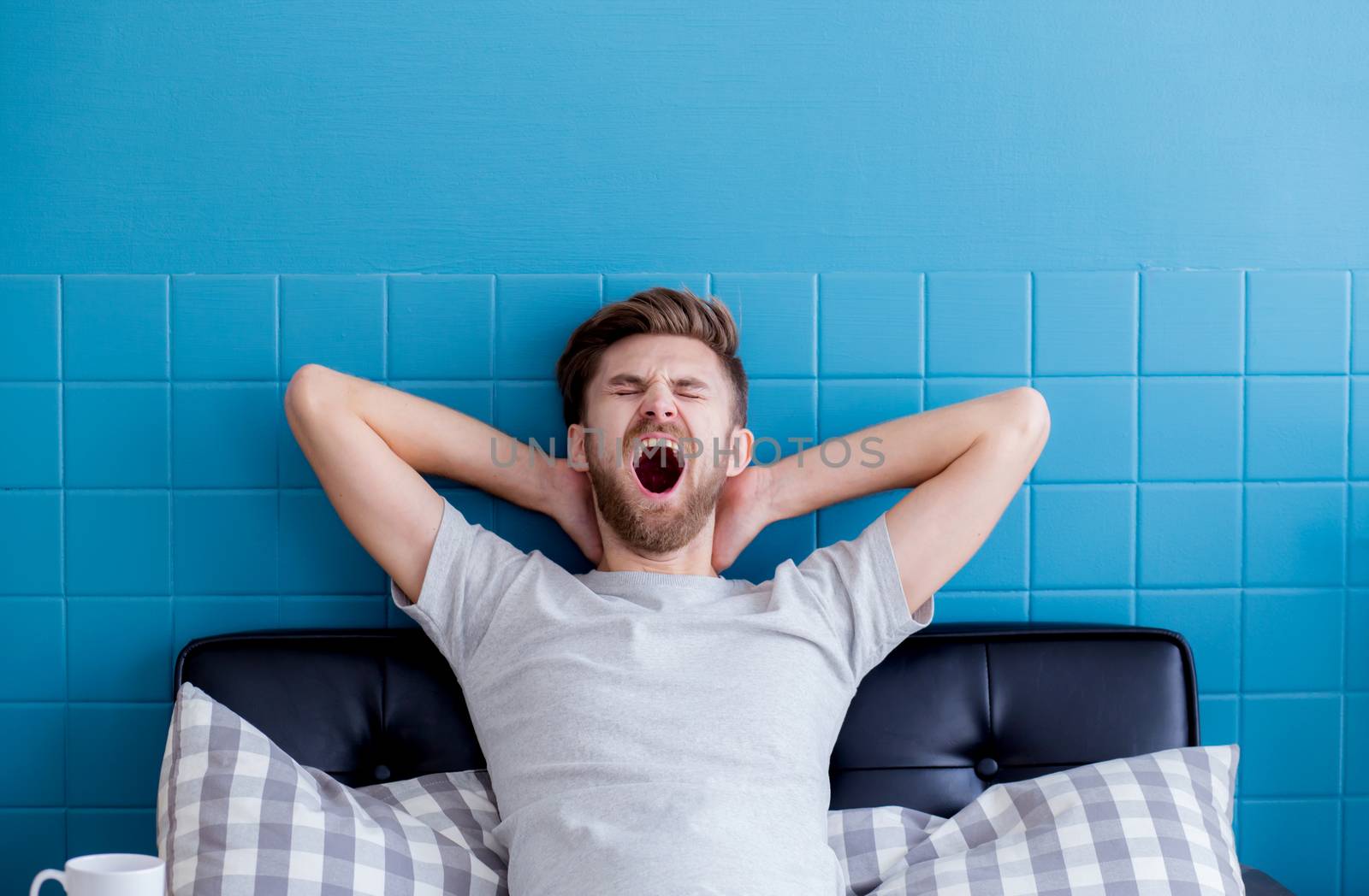 man yawning and going asleep in his  living room