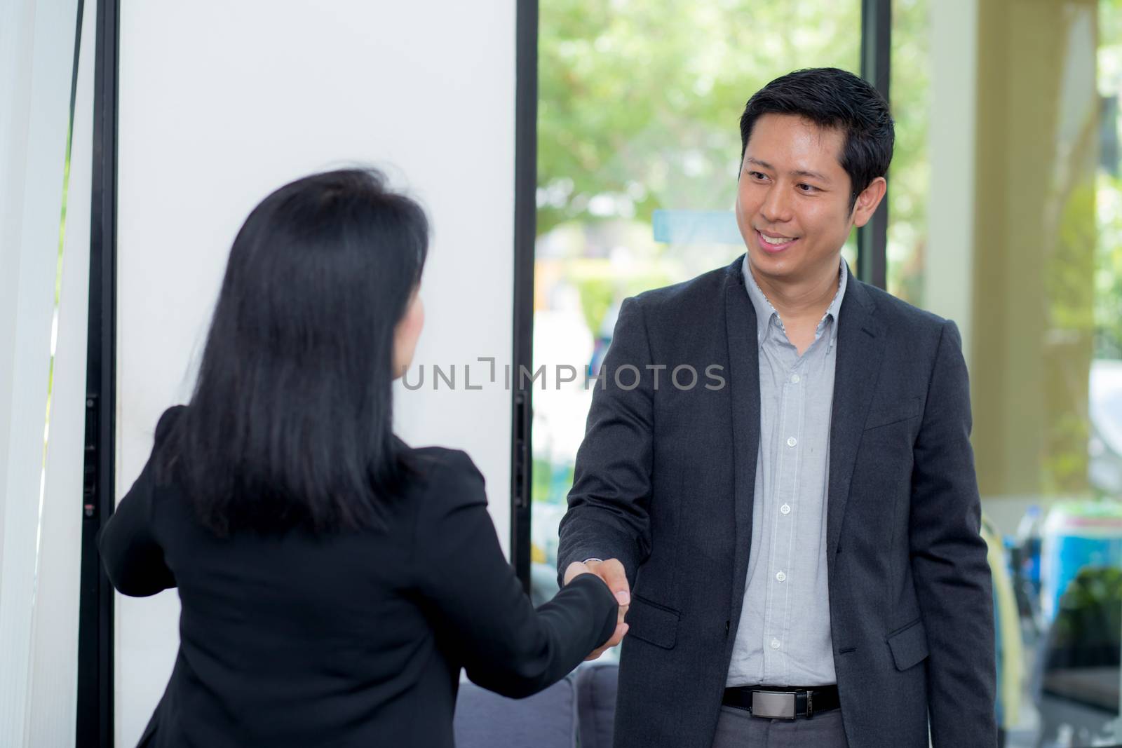 Handshake of businessman and businesswoman after successful business meeting.