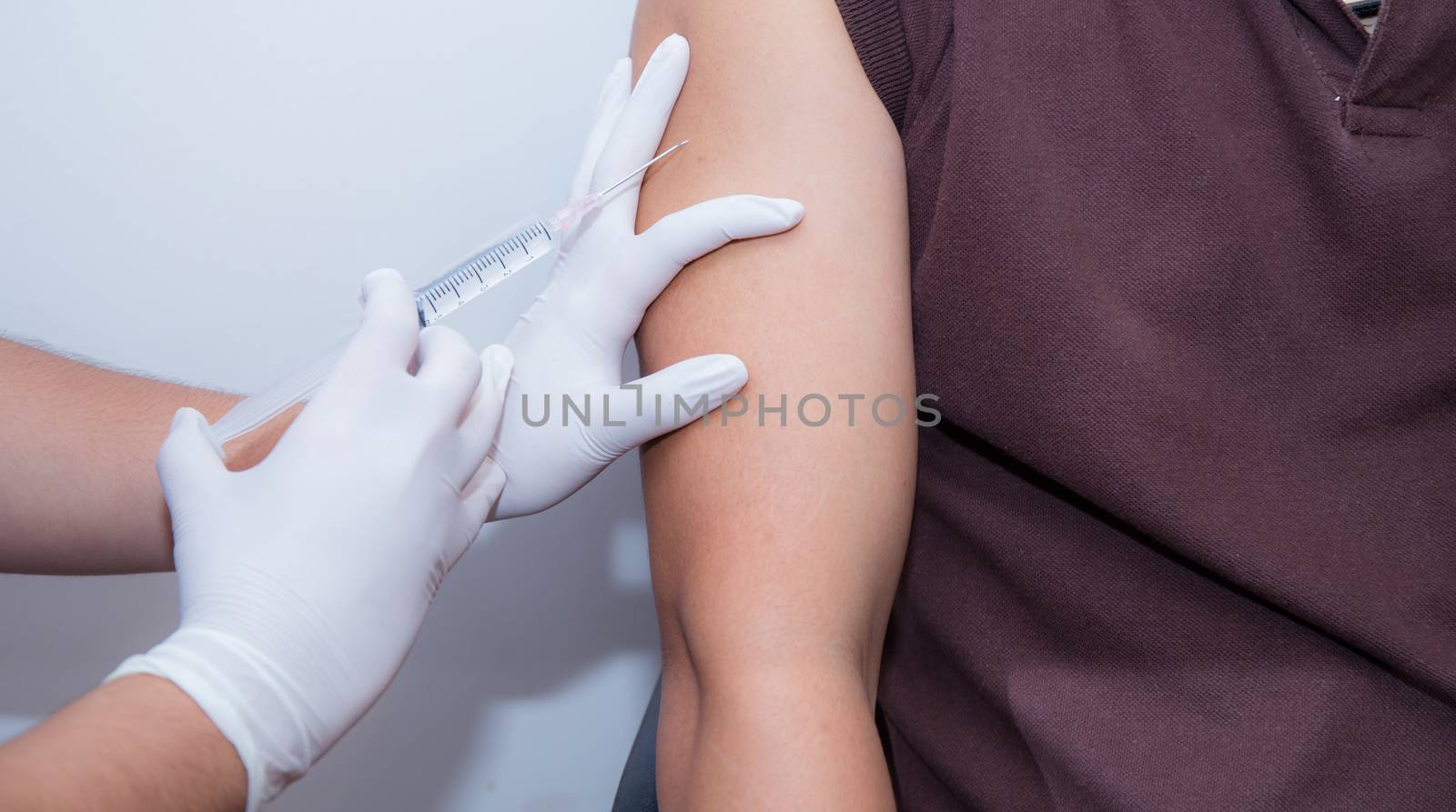 Close-up Of Doctor Injecting Patient With Syringe To Collect Blood