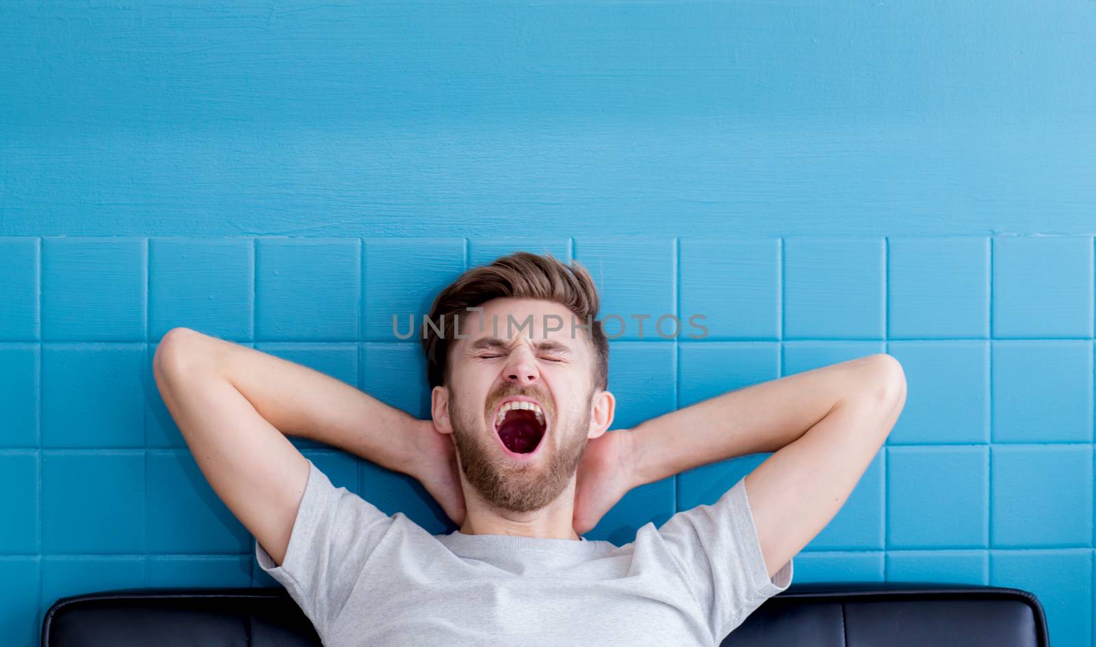 man yawning and going asleep in his  living room