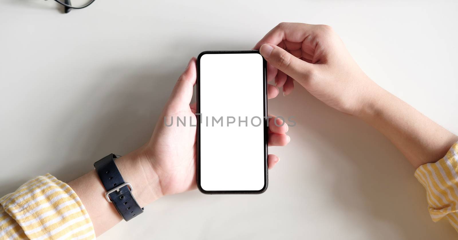 Top view Woman sitting and holding blank screen mock up mobile phone.