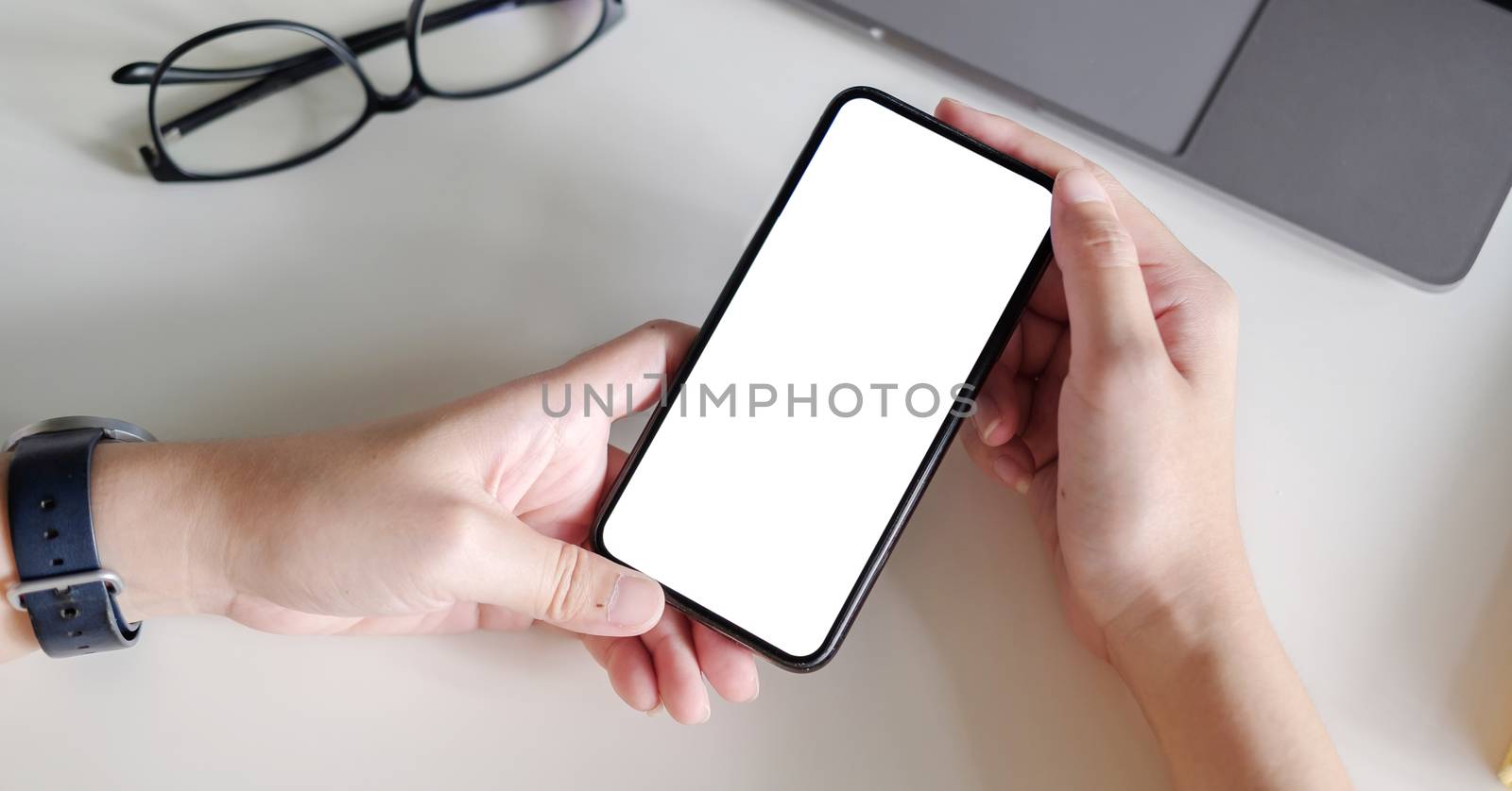 Top view Woman sitting and holding blank screen mock up mobile phone by nateemee