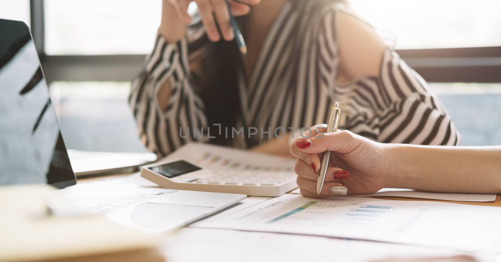 Close up of businessman or accountant working on calculator to calculate business data, accountancy document at meeting room.