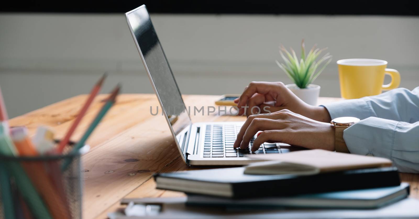 Close up Woman working at home office hand on laptop keyboard by nateemee